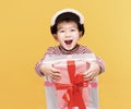 Happy little  boy dressed in winter clothes and holding gift box Royalty Free Stock Photo