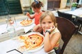 Happy little boy eating kid`s pizza in the restaurant. Royalty Free Stock Photo