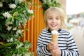 Happy little boy eating tasty ice cream cone outdoors during family stroll. Child have a snack on the go. Gelato is loved delicacy Royalty Free Stock Photo