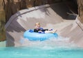 Happy little boy enjoying a wet ride down a water slide Royalty Free Stock Photo