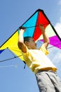 Happy little boy flies a kite into the blue sky Royalty Free Stock Photo