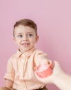 Happy little boy with a gift . Photo on pink background. Smiling boy holds present box. Concept of holidays and birthday