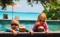 Happy little boy and girl drinking coconut cocktail on beach resort Royalty Free Stock Photo