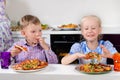 Happy little boy and girl eating Italian pizza