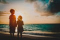 Happy little boy and girl holding hands at sunset