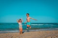 Happy little boy and girl jump on beach Royalty Free Stock Photo