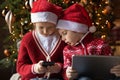 Happy little boy and girl siblings using Christmas tech presents. Royalty Free Stock Photo