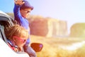 Happy little boy and girl travel by car in Royalty Free Stock Photo