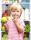 Happy little boy with green apple showing his Royalty Free Stock Photo