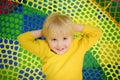 Happy little boy having fun in amusement in play center. Child playing on indoor playground Royalty Free Stock Photo