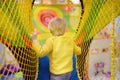 Happy little boy having fun in amusement in play center. Child playing on indoor playground Royalty Free Stock Photo