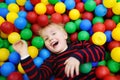 Happy little boy having fun in ball pit with colorful balls Royalty Free Stock Photo