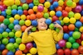 Happy little boy having fun in ball pit with colorful balls. Child playing on indoor playground Royalty Free Stock Photo