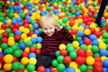 Happy little boy having fun in ball pit with colorful balls Royalty Free Stock Photo