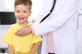 Happy little boy having fun while is being examine by doctor by stethoscope. Health care, insurance and help concept Royalty Free Stock Photo