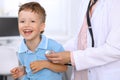 Happy little boy having fun while is being examine by doctor by stethoscope. Health care, insurance and help concept Royalty Free Stock Photo