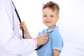 Happy little boy having fun while is being examine by doctor by stethoscope. Health care, insurance and help concept Royalty Free Stock Photo