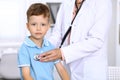 Happy little boy having fun while is being examine by doctor by stethoscope. Health care, insurance and help concept Royalty Free Stock Photo