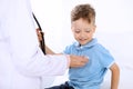 Happy little boy having fun while is being examine by doctor by stethoscope. Health care, insurance and help concept Royalty Free Stock Photo