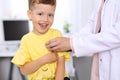 Happy little boy having fun while is being examine by doctor by stethoscope. Health care, insurance and help concept Royalty Free Stock Photo