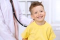 Happy little boy having fun while is being examine by doctor by stethoscope. Health care, insurance and help concept Royalty Free Stock Photo