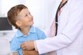 Happy little boy having fun while is being examine by doctor by stethoscope. Health care, insurance and help concept Royalty Free Stock Photo