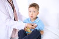 Happy little boy having fun while is being examine by doctor by stethoscope. Health care, insurance and help concept Royalty Free Stock Photo