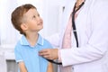 Happy little boy having fun while is being examine by doctor by stethoscope. Health care, insurance and help concept Royalty Free Stock Photo