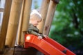 Happy little boy having fun on outdoor playground/on slide Royalty Free Stock Photo