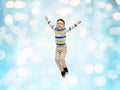 Happy little boy jumping in air over blue lights Royalty Free Stock Photo