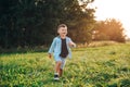 Happy little boy jumping on grass in summer day Royalty Free Stock Photo