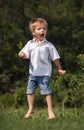 Happy little boy is jumping outdoor.