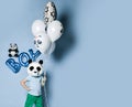 Happy little boy kid in panda mask with bunch of balloons for birthday part.  Translation  from Russian on balloon: I love you Royalty Free Stock Photo