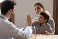 Happy little boy kid giving high five to friendly doctor. Royalty Free Stock Photo