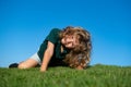 Happy little boy laying on grass. Kids exploring nature, summertime.