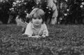 Happy little boy lying on the grass at the spring day. Portrait of a smiling child lying on green grass in park. Kids on