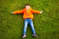 Happy little boy lying on green grass in park Royalty Free Stock Photo