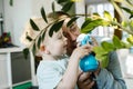 Happy little boy and man plash water on a home flower. Father dad and toddler son having fun