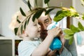 Happy little boy and man plash water on a home flower. Father dad and toddler son having fun