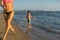 Happy little boy with mother running on summer beach. Positive h Royalty Free Stock Photo