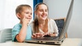 Happy little boy with mother smiling and looking on laptop screen. Amazed child using laptop computer Royalty Free Stock Photo