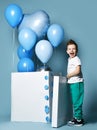 Happy little boy with pastel color blue balloons and empty white box for birthday party Royalty Free Stock Photo