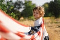 Happy little boy patriot running in the field with American flag Royalty Free Stock Photo