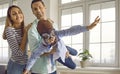 Happy little boy in pilot hat and goggles playing and having fun with his parents at home Royalty Free Stock Photo