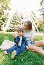 Happy little boy is playing, blowing soap bubbles together with his happy young mother. Weekend breaks, caring parenting and child Royalty Free Stock Photo