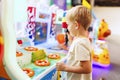 Happy little boy playing fun games on arcade machine at an amusement park Royalty Free Stock Photo