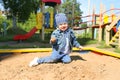 Happy little boy playing with sand on playground Royalty Free Stock Photo