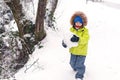 Happy little boy playing in snow. Little child having fun on winter day. Winter holidays. Funny boy wearing warm outwear. Winter