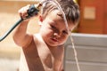 Happy little boy playing with water hose in the backyard Royalty Free Stock Photo