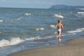 Happy little boy running far away along the sea beach Royalty Free Stock Photo